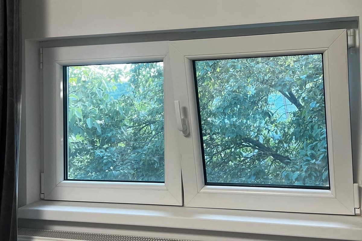 Fereastra termopan alba din PVC cu maner central, cu ochiul din dreapta rabatat in pozitie oscilobatanta